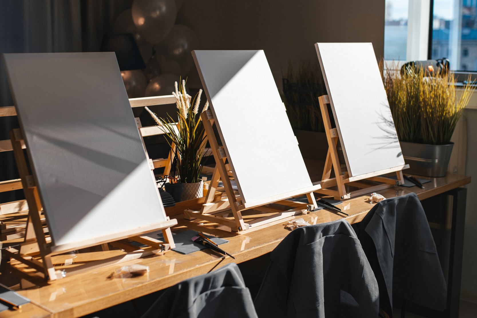 background with easels in art class. Empty art class with easels and canvases in the sun
